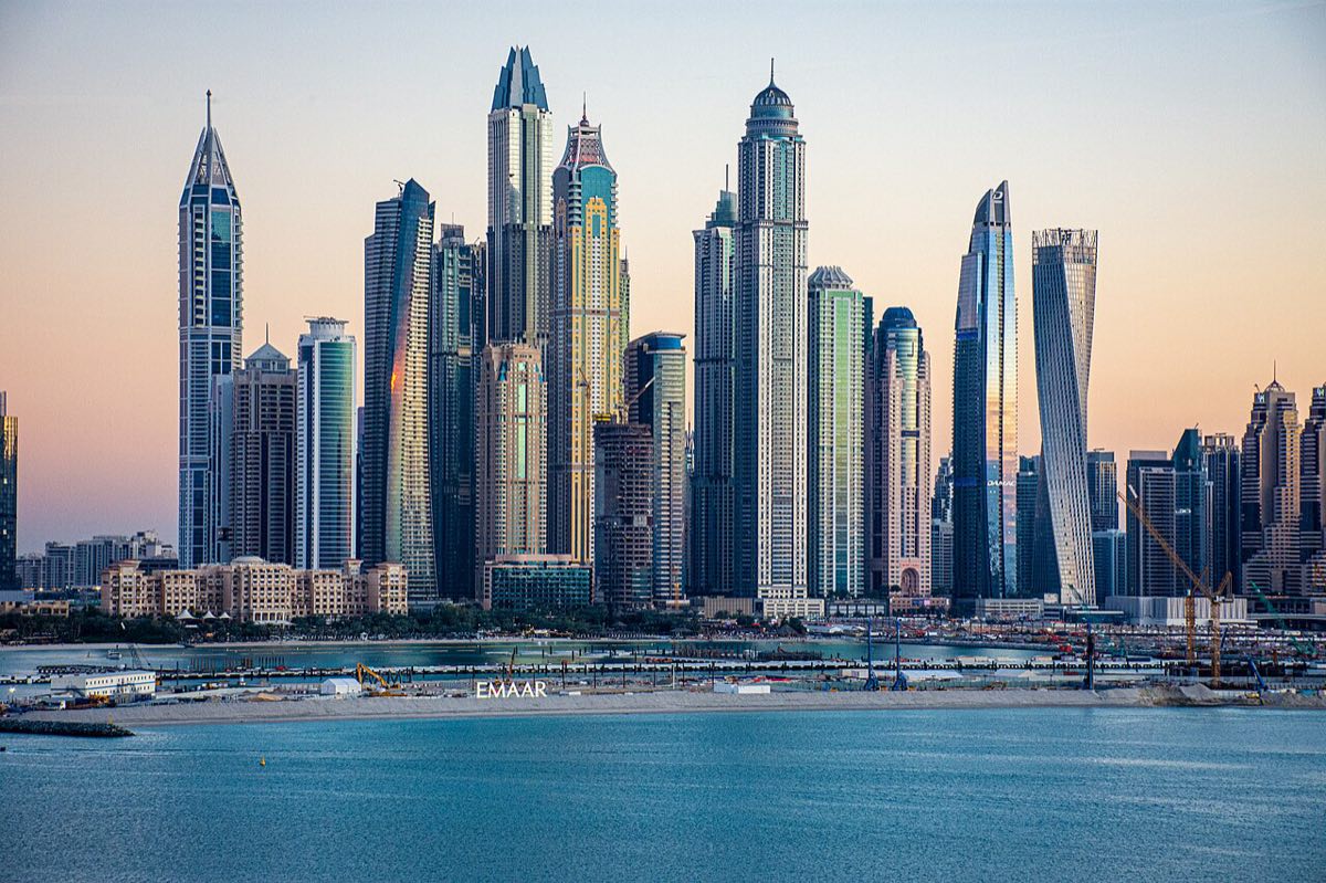 High-rise towers of the Dubai Marina skyline at dusk, seen across the water.